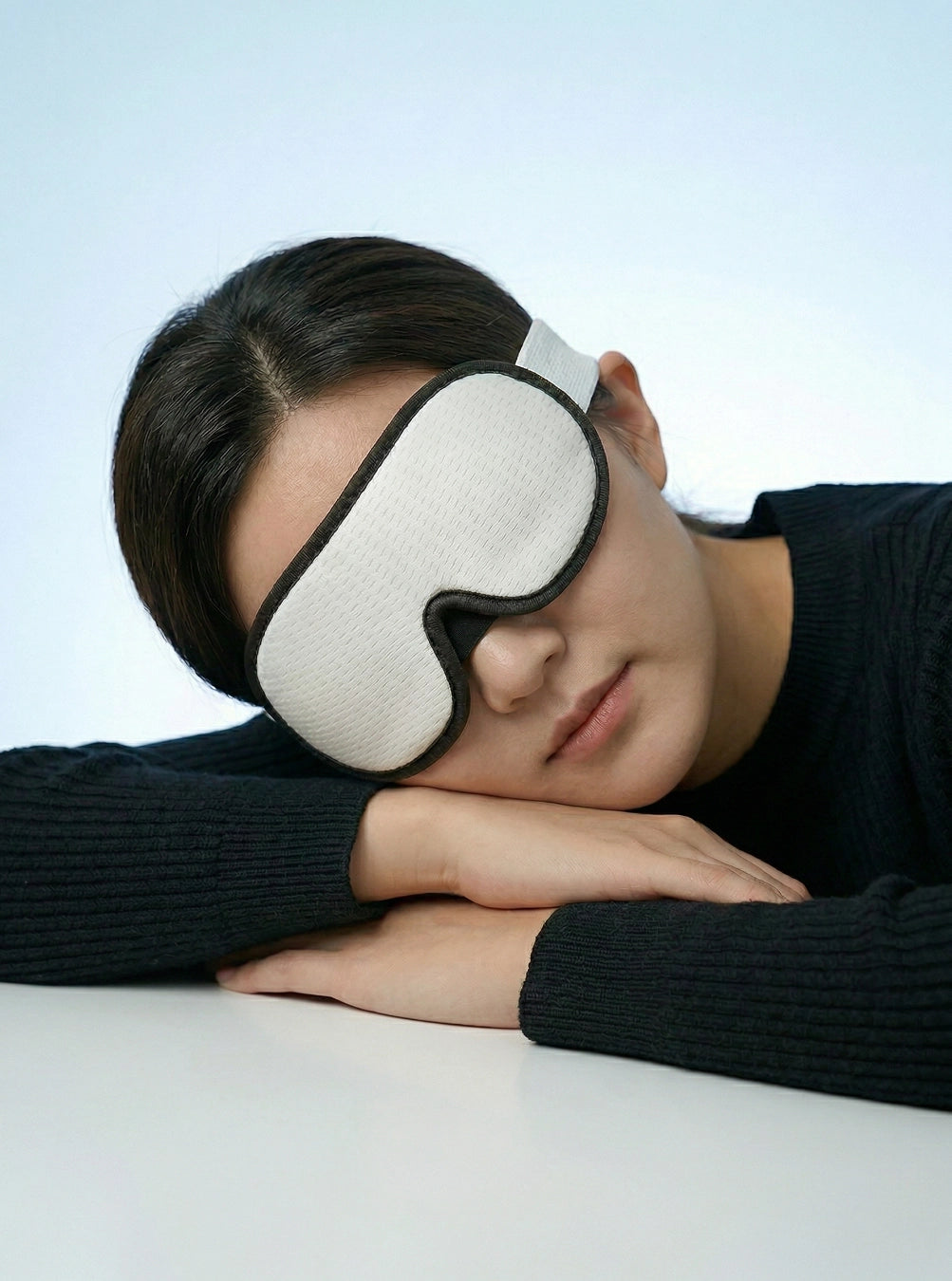 Person wearing a white sleep mask on a plain background, cloudwhite