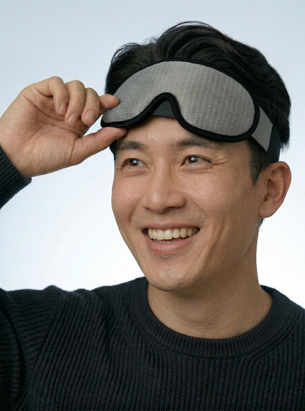Man wearing a gray sleep mask against a light blue background, stormgrey