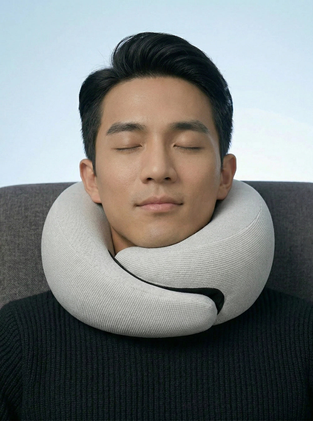 Person using a neck pillow against a neutral background, stormgrey